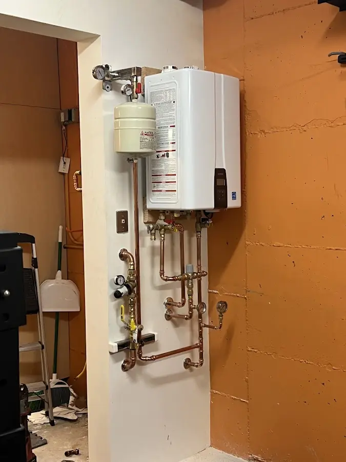 Plumbing technician inspecting water heater connections in Jenkintown